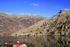 Walker at Crib Goch reflected in Llyn Llydaw
