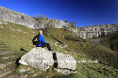 Walker at Malham Cove, limestone cliffs, Malhamdale