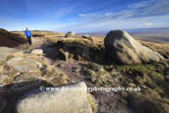 Walker on Gritstone rocks, Shelf Moor, High Peak