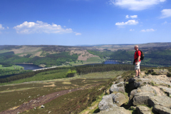 Walker on Win Hill overlooking Ladybower reservoir