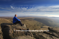 Walker on Gritstone rocks, Shelf Moor, High Peak